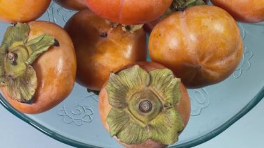 Hurma meyveleri. Klasik cam meyve kâsesinde Fuyu çeşidi.