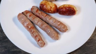Beyaz tabakta farklı ızgara sosisler, yakın çekim.