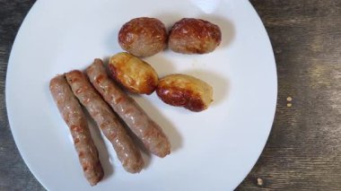 Siyah ahşap yüzeyde farklı ızgara sosisler.