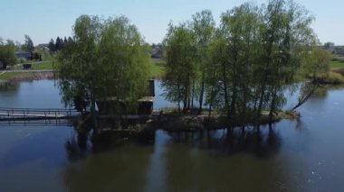 Yaya köprüsü, kulübe ve baharda ağaçlarla dolu bir ada.