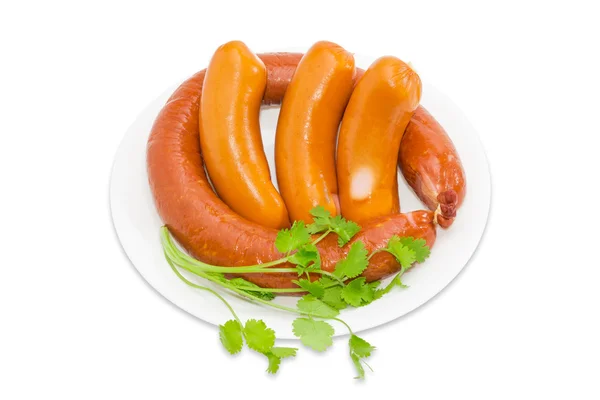 Sausages with branch of coriander on a light background — Stockfoto