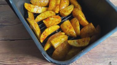 Havalandırma kabında baharatlı çiğ patates dilimleri.