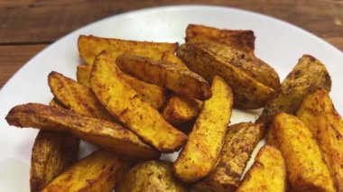 Köy tabaklarında baharat bulunan fırında patates dilimleri.