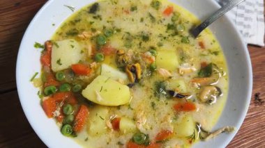 Deniz mahsullü kremalı çorba ve kaşıklı sebze, üst manzara.