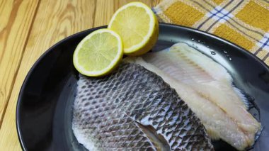 Kırsal masada siyah tabakta çiğ dourade fileto.