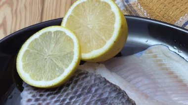 Kırsal masada siyah tabakta çiğ dourade fileto.