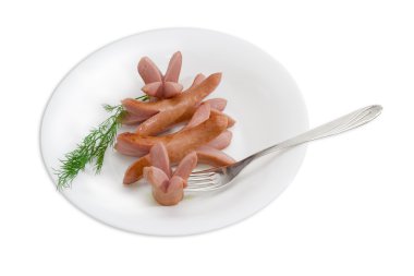 Grilled frankfurters, branch of dill and a fork