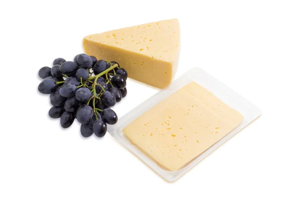 Piece of cheese, sliced cheese and bunch of grapes — Stockfoto