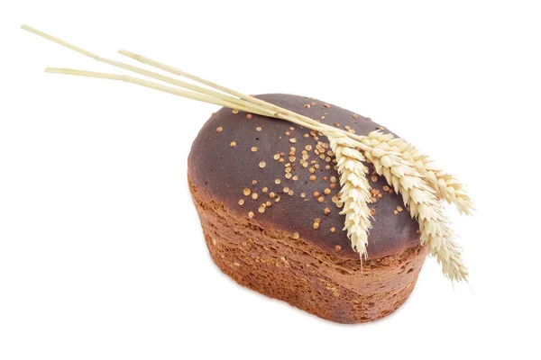 Целая буханка бурого хлеба с кориандром и тремя ушами пшеницы — стоковое фото
