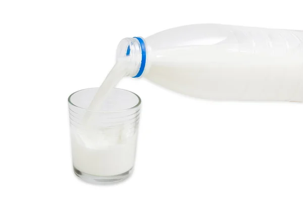 La leche se vierte de una botella en un vaso — Foto de Stock