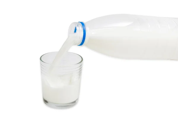 Milch wird aus der Flasche in ein Glas gegossen — Stockfoto