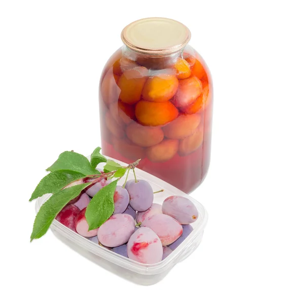 Čerstvé švestky v zásobníku a konzervované švestky do sklenic — Stock fotografie