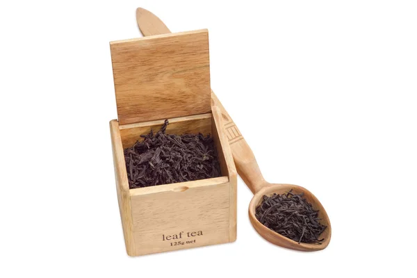 Feuilles de thé noir dans une boîte en bois et cuillère — Photo