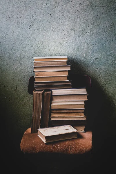 Vintage Background with Old Books. Stack of Books Folded on a Chair. Fragments of the Interior of the Old Library.