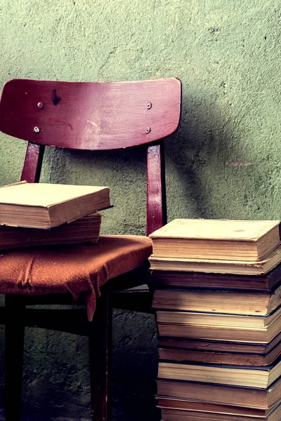 Vintage Background with Old Books. Stack of Books Folded on a Chair. Fragments of the Interior of the Old Library.