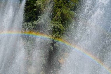 Açıkça görülüyor ki gökkuşağı bir çeşmenin büyük damlaları arasında oluşmuş.