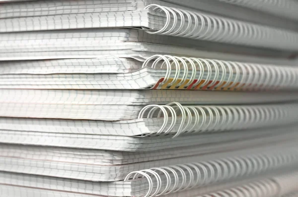 A stack of notebooks in a cage with springs — Stock Photo, Image