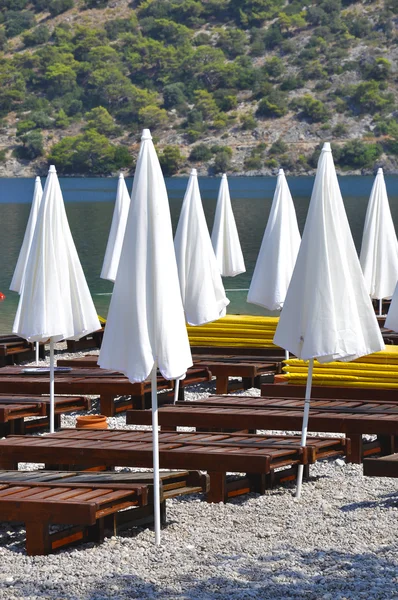 Sombrillas blancas cerradas en la playa — Foto de Stock