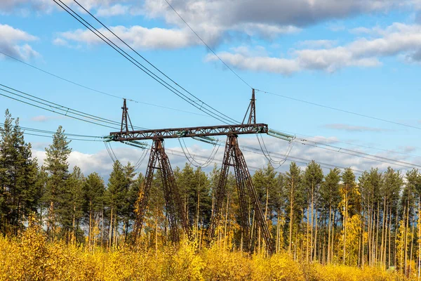 Rusty i czarna linia energetyczna jest na niebieskim niebie z białymi chmurami tła — Zdjęcie stockowe