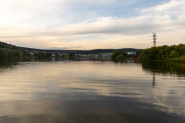 Yansımalı gölet ve sarı tüylü çim ve kamış yaz akşamında.