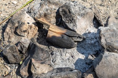 Gri ve kahverengi büyük taşlar ve şenlik ateşi için huş ağacı gövdesi ormandaki bir şöminede.