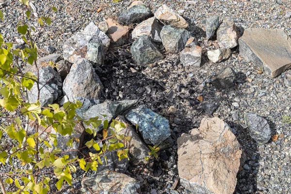 Γκρι και καφέ μεγάλες πέτρες και πεύκο κορμό για μια φωτιά είναι σε ένα τζάκι στο δάσος — Φωτογραφία Αρχείου
