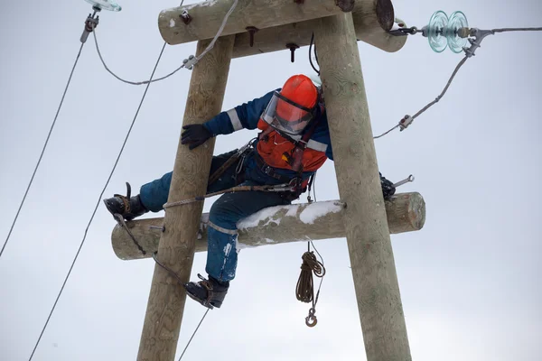 Elettricista che lavora su un traliccio elettrico — Foto Stock