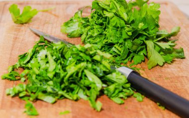 Kesme tahtası üzerinde doğranmış otlar