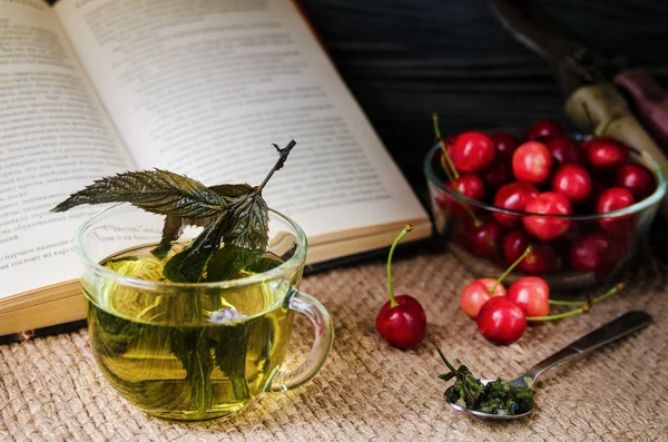 Mint tea in a glass cup with cherries — Stock Photo, Image