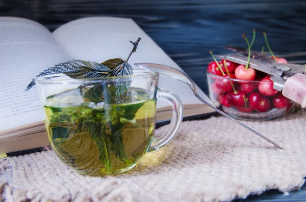 Mint tea in a glass cup with cherries — Stock Photo, Image