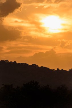 Çekici bir geçmişi olan siluet dağı, parlak sarı gökyüzü olan gün batımı.