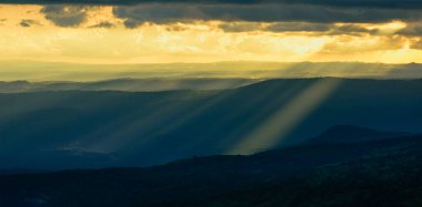 Tayland 'ın Phu Kra Dueng Ulusal Parkı' nda günbatımı gökyüzü ve bulutlu yeşil dağ tepelerinin panoramik manzarası