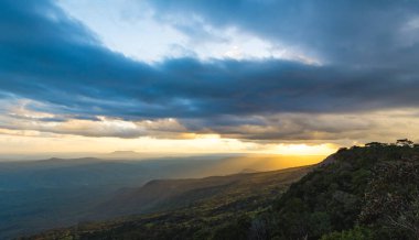 Güneş ışığıyla dağ sırtları, günbatımı gökyüzü ve bulanık kayalar. Tayland 'ın Phu Kra Dueng Ulusal Parkı