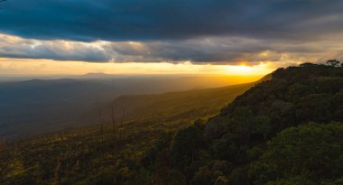 Tayland 'ın Phu Kra Dueng Ulusal Parkı' nda günbatımı gökyüzü ve bulutlu yeşil dağ tepelerinin panoramik manzarası