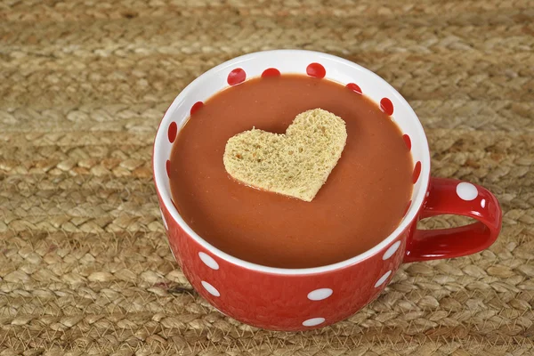 Coração de pão flutuando na sopa de tomate — Fotografia de Stock