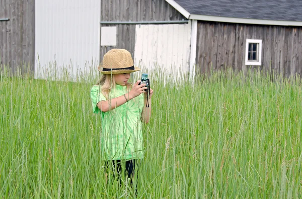 Liten flicka tar ett fotografi med retro camer — Stockfoto