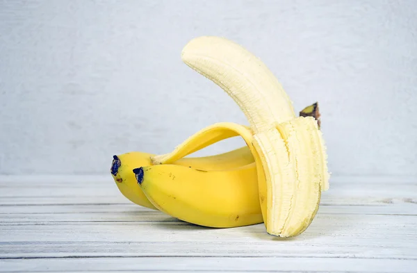 Plátano pelado sobre madera — Foto de Stock
