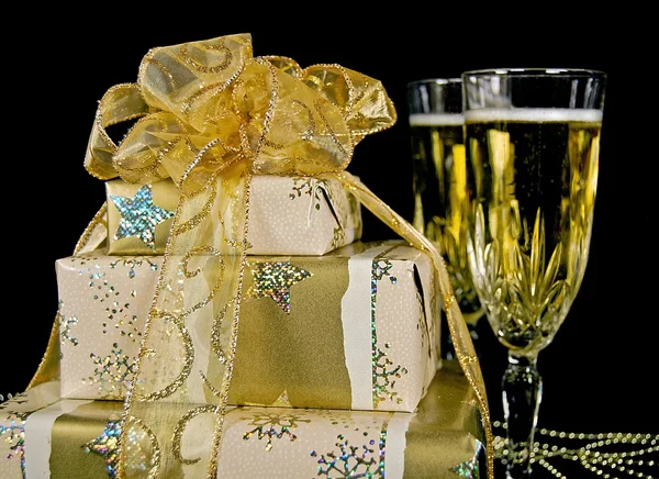 Gold Christmas gifts and champagne — Stock Photo, Image