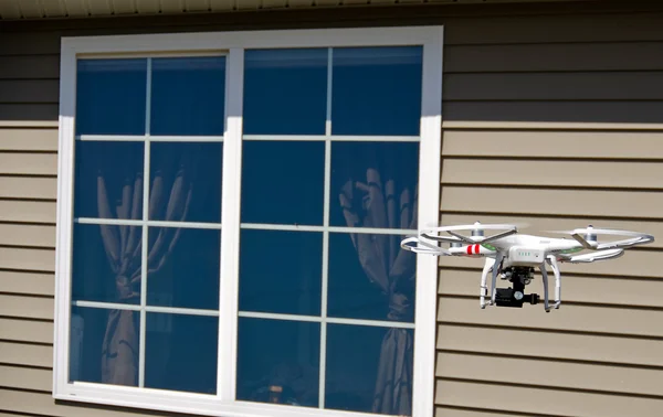 Drone hovering near house window — Stock Photo, Image