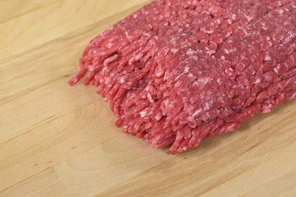 Raw hamburger on butcher block — Stock Photo, Image