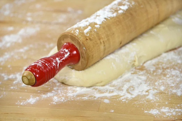 Retro wooden rolling pin on bread dough — Stock Photo, Image