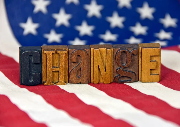 Change concept using old wooden letterpress type on American flag — Stock Photo, Image