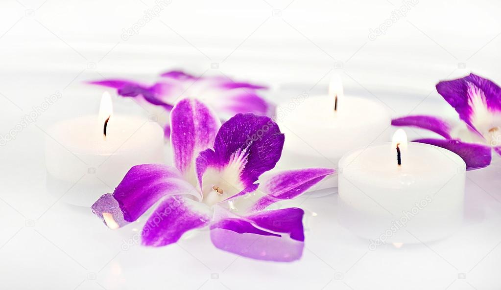 orchid blooms and candles in water