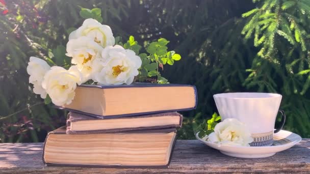 美しい夏の構図 コーヒーカップ 白いバラの腰の花束自然緑の背景に花や本 良い朝 夏の気分 幸福の概念 — ストック動画