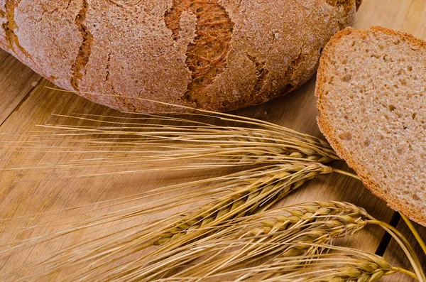 Kulatý pecen žitného chleba na dřevěný stůl — Stock fotografie