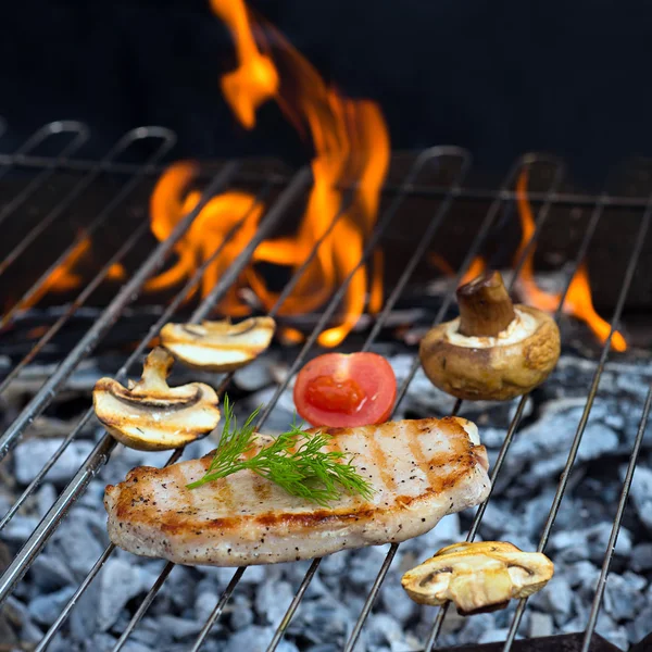 Steaks and mushrooms on grill — Stock Photo, Image