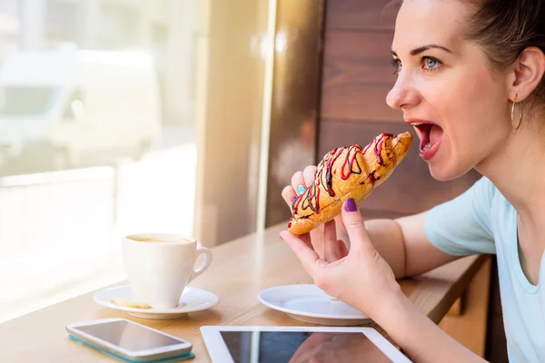 Frau isst ein Croissant — Stockfoto