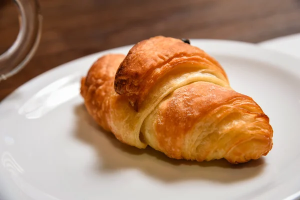 Croissant on wite plate — Stock Photo, Image