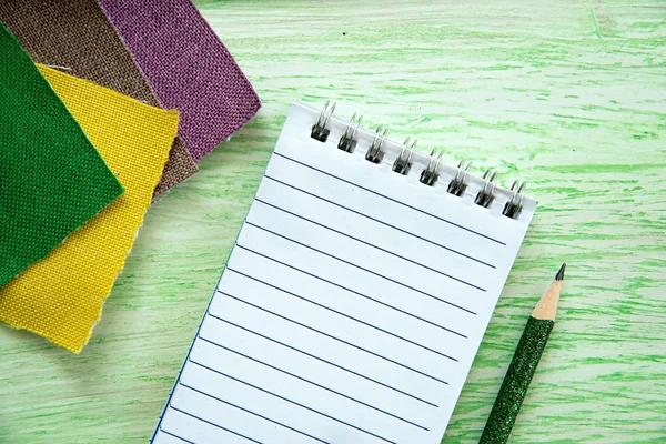 Notebook a barevné tkaniny — Stock fotografie