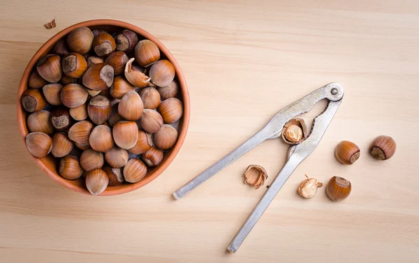 Hazelnuts and nutcracker on table — Stock Photo, Image